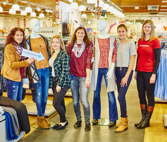 Eine youngCaritas-Mitarbeiterin in der C&A-Filiale in Ybbs an der Donau mit den jngen Teilnehmerinnen des "youngHeroes Day" und zwei Schaufensterpuppen