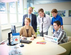 Youngherosday 2015 Sparkasse drei Burschen sehen beim Arbeiten mit dem Computer zu.