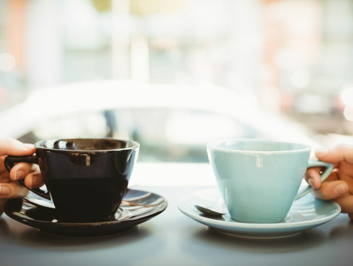 Friends holding cup of coffee